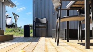 A wooden deck with outdoor furniture, including a chair and a table. - 4 Star Holiday Home in Thisted (Thisted)
