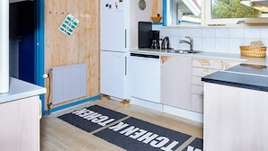 A compact kitchen with a white refrigerator, a coffee maker, and a sink. - 4 Star Holiday Home in Thisted (Thisted)