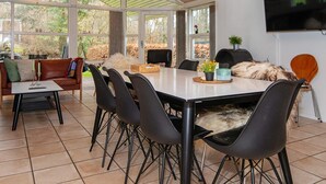 Un comedor moderno con una mesa grande, sillas negras y una lámpara colgante azul.