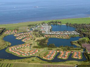 A residential area with houses arranged around a central lake, connected by roads. - Holiday Home in Otterndorf (Otterndorf)
