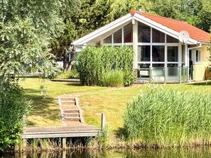 A house with a red roof, large windows, and a satellite dish. - Holiday Home in Otterndorf (Otterndorf)