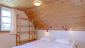 A bedroom with a bunk bed, a window with curtains, and a wooden ceiling. - 6 Person Holiday Home in Ringkobing-by Traum (Ringkobing)