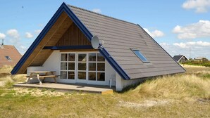A modern beach house with a sloped roof, large windows, and a picnic table. - 6 Person Holiday Home in Ringkobing-by Traum (Ringkobing)