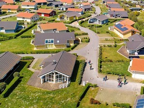 A residential area with houses, a central road, and a large building with a distinctive roof. - Holiday Home in GrÃ¶mmitz (Groemitz)