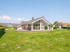 A single-story house with a large glass front, a covered patio, and a well-maintained lawn. - Holiday Home in GrÃ¶mmitz (Groemitz)