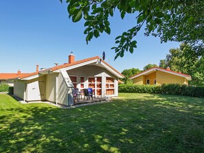 A two-story house with a covered patio and a separate garage. - Holiday Home in GrÃ¶mmitz (Groemitz)
