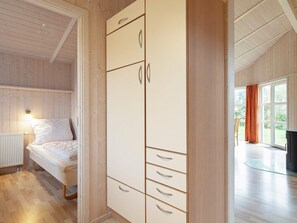 A bedroom with a bed, a wardrobe, and a view of an outdoor area. - Holiday Home in GrÃ¶mmitz (Groemitz)