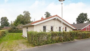 A single-story house with a sloped roof, a visible chimney, and a street lamp. - Holiday Home in GrÃ¶mmitz (Groemitz)