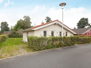 A single-story house with a sloped roof, a visible chimney, and a street lamp. - Holiday Home in GrÃ¶mmitz (Groemitz)