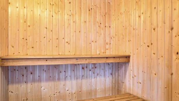 A sauna with wooden benches and a sloped ceiling.