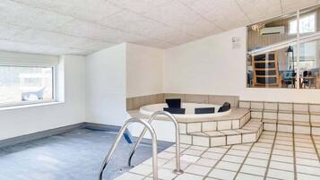 Un área de spa con una bañera de hidromasaje, una escalera y un ventanal.