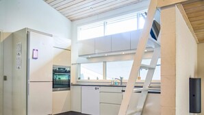 A kitchen with a built-in oven, a dishwasher, and a window above the sink.