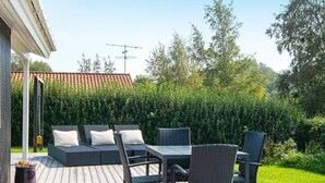 An outdoor patio with wicker furniture, a table, and a sofa.