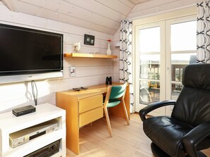 A room with a flat-screen TV, wooden desk, chair, and a black leather chair. - 5 Star Holiday Home in Skagen (Skagen)