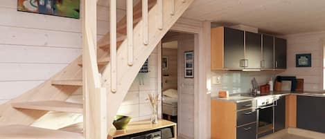 A modern kitchen with wooden cabinets, a built-in oven, and a small island.