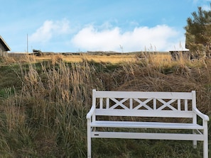 A white bench in a grassy field with a clear sky. - 5 Star Holiday Home in Skagen (Skagen)