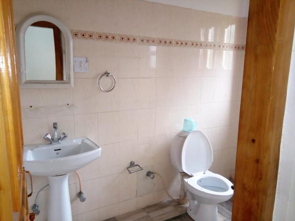 A bathroom with a sink, toilet, and a mirror.