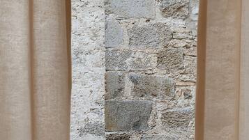 A stone wall with a rough texture and irregularly shaped stones.