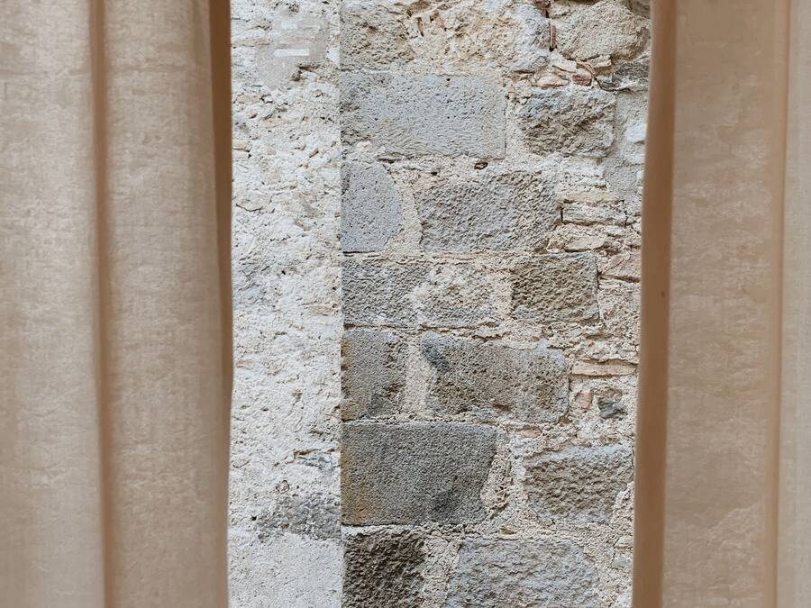 A stone wall with a rough texture and irregularly shaped stones.