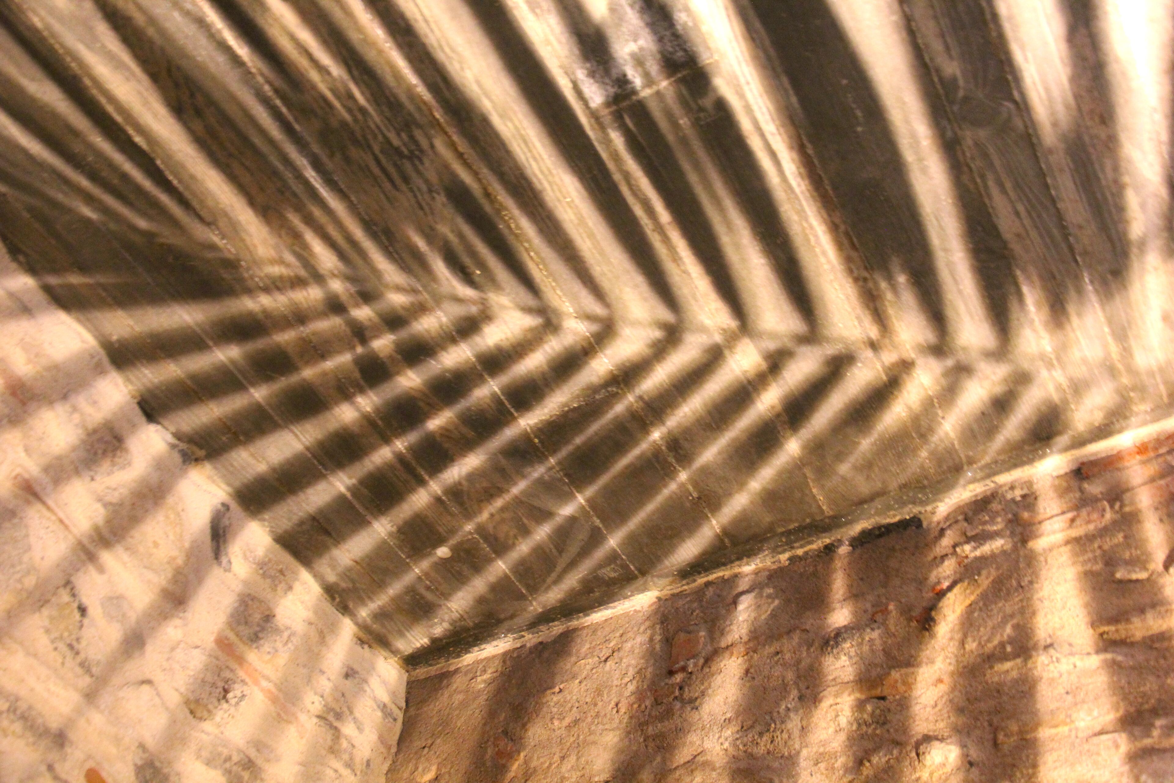 Un gros plan d’un mur à la texture particulière, orné d’un motif géométrique.