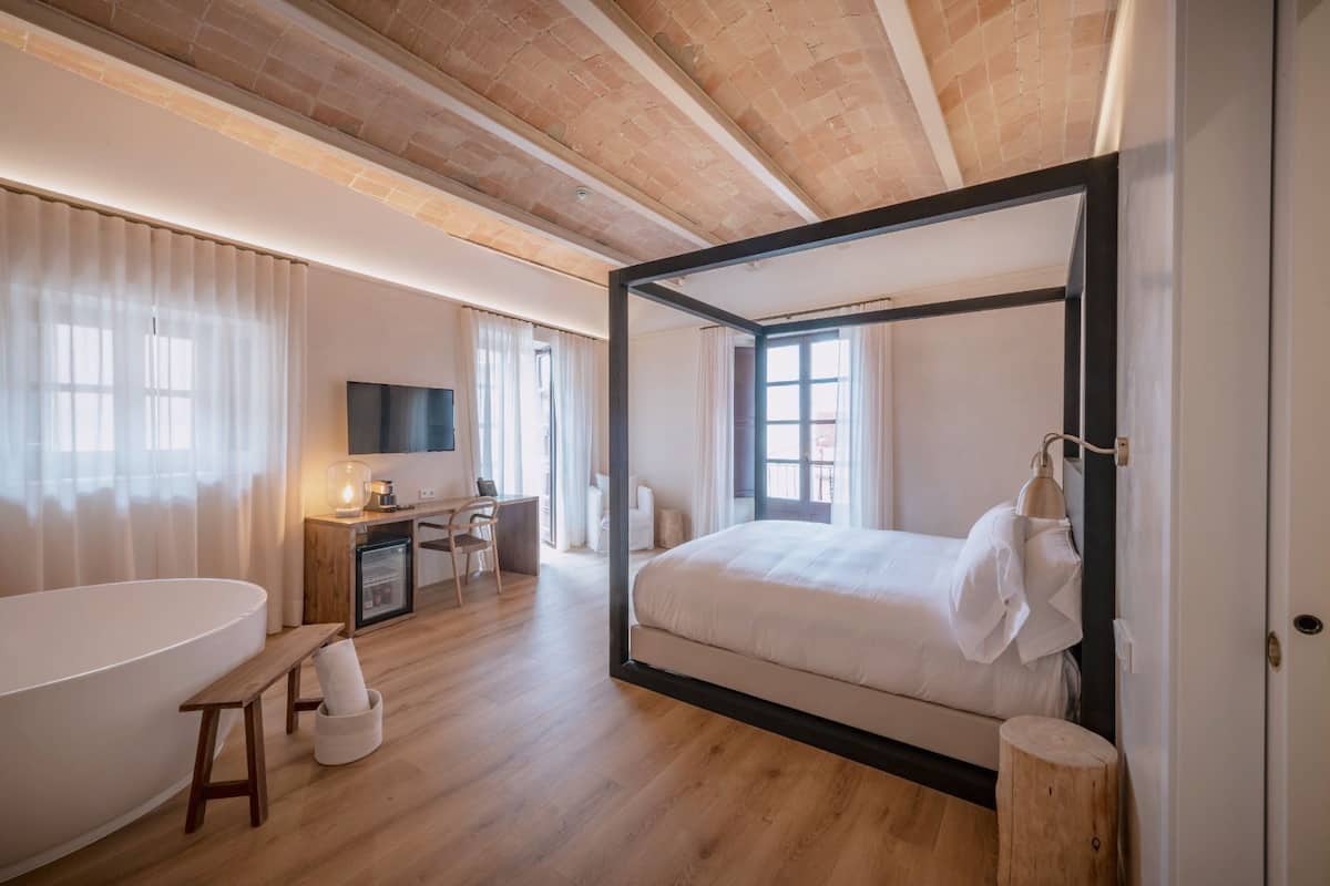 Un dormitorio moderno con una cama grande, un escritorio y una bañera.