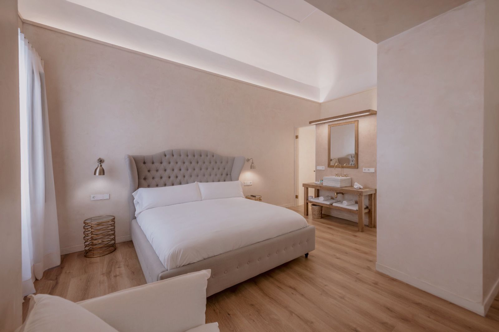 Ein Schlafzimmer mit einem großen Bett, einem Nachttisch, einem Spiegel und einem Holzboden.