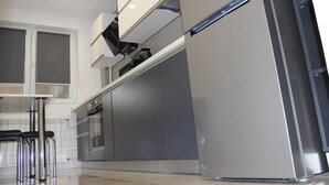 Eine moderne Küche mit Edelstahlgeräten, einem Backofen und einem Kühlschrank.