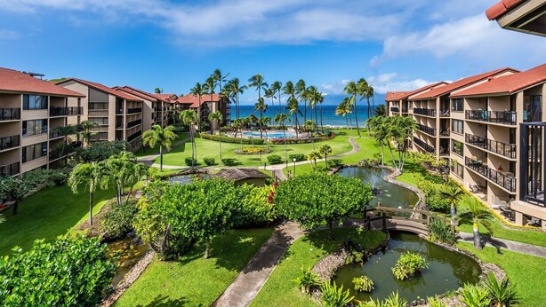 A resort with multiple-story buildings, a swimming pool, palm trees, and a view of the ocean. - Papakea H404 3 Bedroom Condo by RedAwning (Lahaina)