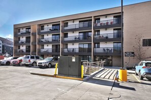 A multi-story parking garage with a building labeled 'NEW CLAIM CONDOMINIUMS' in the background.