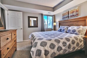 Un dormitorio con cama, cómoda, espejo y obras de arte.