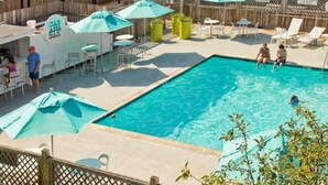 Ein Poolbereich mit Bar, Sonnenschirmen und Liegestühlen.
