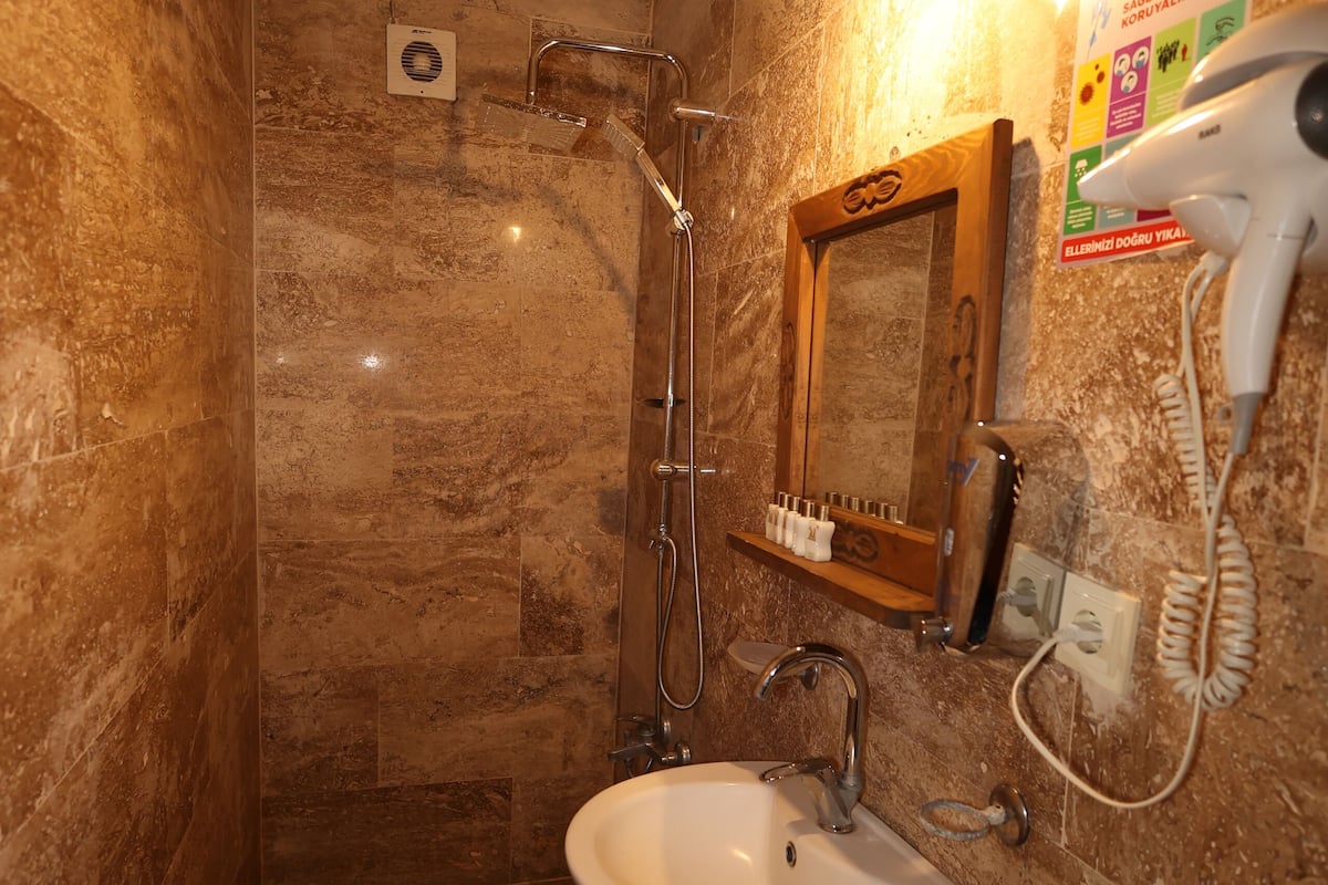 A bathroom with a shower, sink, and toilet.