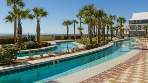 A swimming pool with palm trees and a view of the ocean.