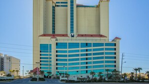 A large hotel with a central tower and multiple floors, featuring a prominent entrance and a clear view of the surrounding area.