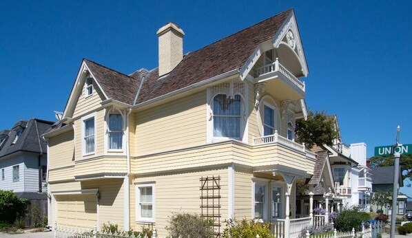 A two-story Victorian-style house with a gabled roof, dormer windows, and a front porch. - Daffodil House - Pacific Grove House - Block to the Beach (Pacific Grove)