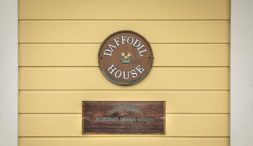 A sign reading "DAFFODIL HOUSE" with a smaller plaque below stating "Pacific Coast Heritage Design Award".