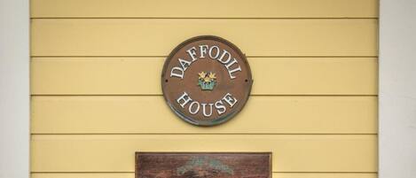 A sign reading "DAFFODIL HOUSE" with a smaller plaque below stating "Pacific Coast Heritage Design Award".