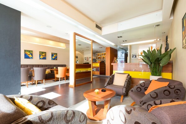Rebost d'hotel modern amb zona d'estar, taulell de recepció i vista de l'interior.