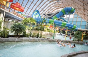 Ein großer Indoor-Wasserpark mit einer langen Wasserrutsche, einem Poolbereich und verschiedenen Wasserspielen.