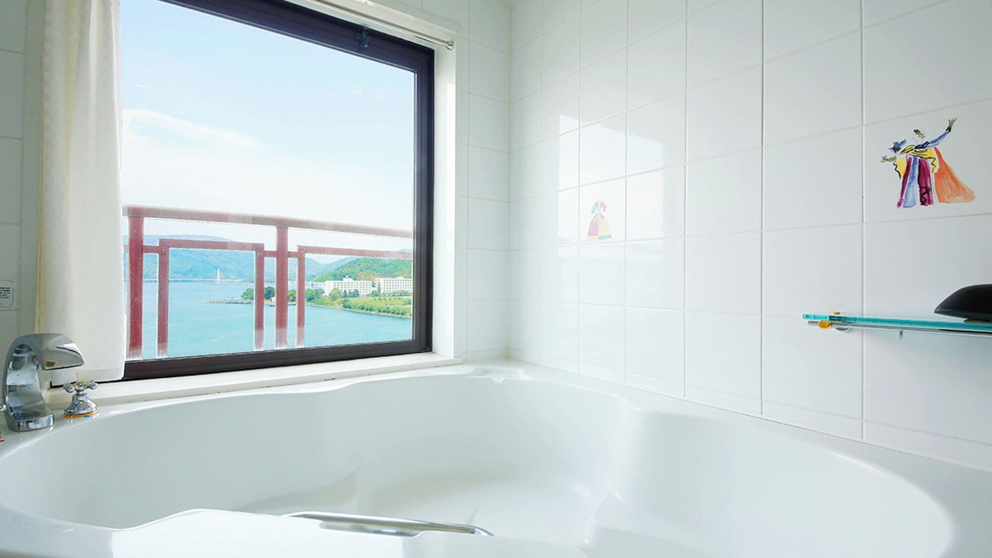 Une salle de bain avec une grande baignoire, une fenêtre donnant sur un pont et des immeubles, et une étagère contenant des articles de toilette.