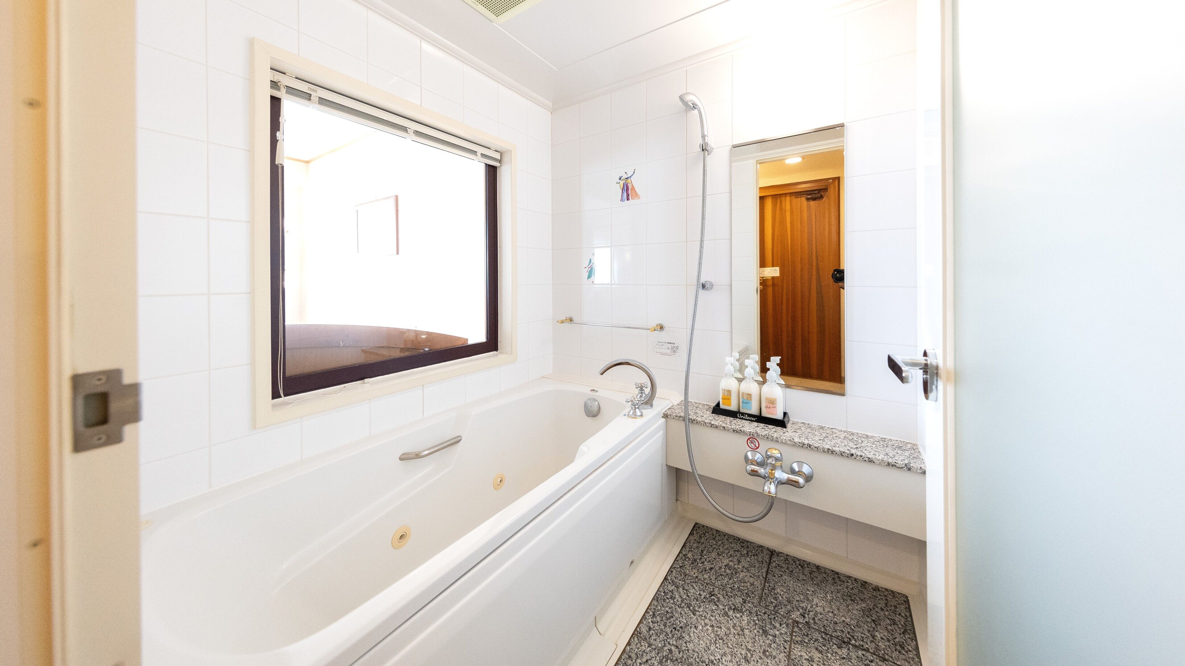 A modern bathroom with a bathtub, a shower, and a vanity with a mirror.