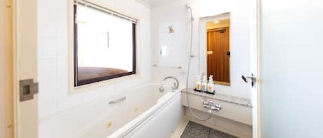 A modern bathroom with a bathtub, a shower, and a vanity with a mirror.