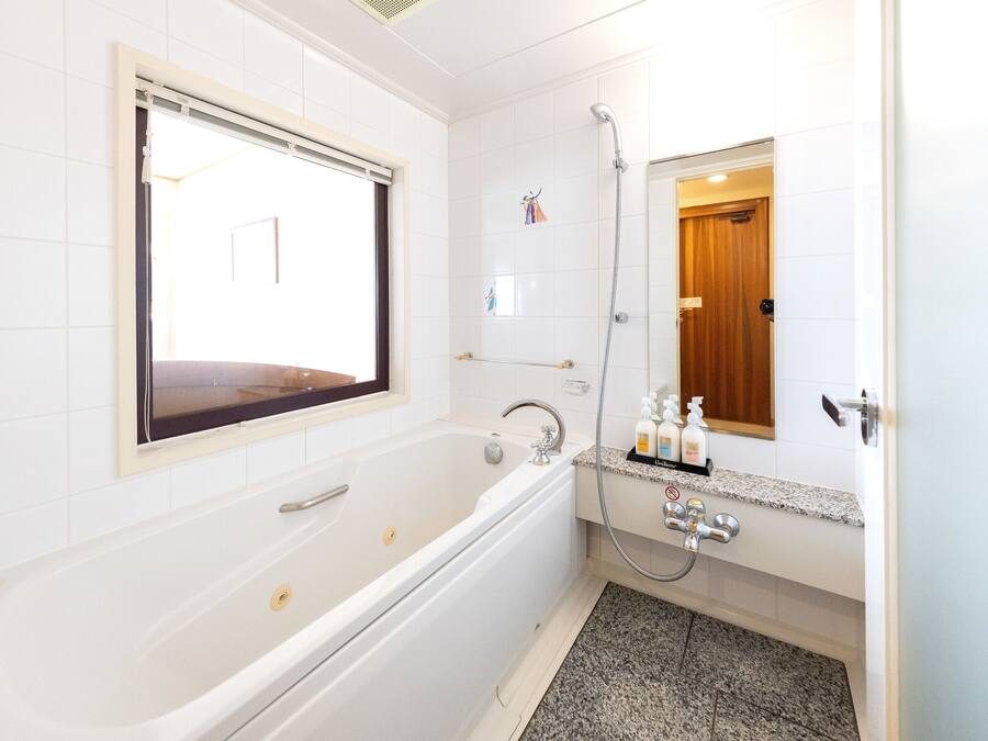 A modern bathroom with a bathtub, a shower, and a vanity with a mirror.