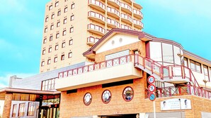 A multi-story building with a prominent balcony and a staircase.