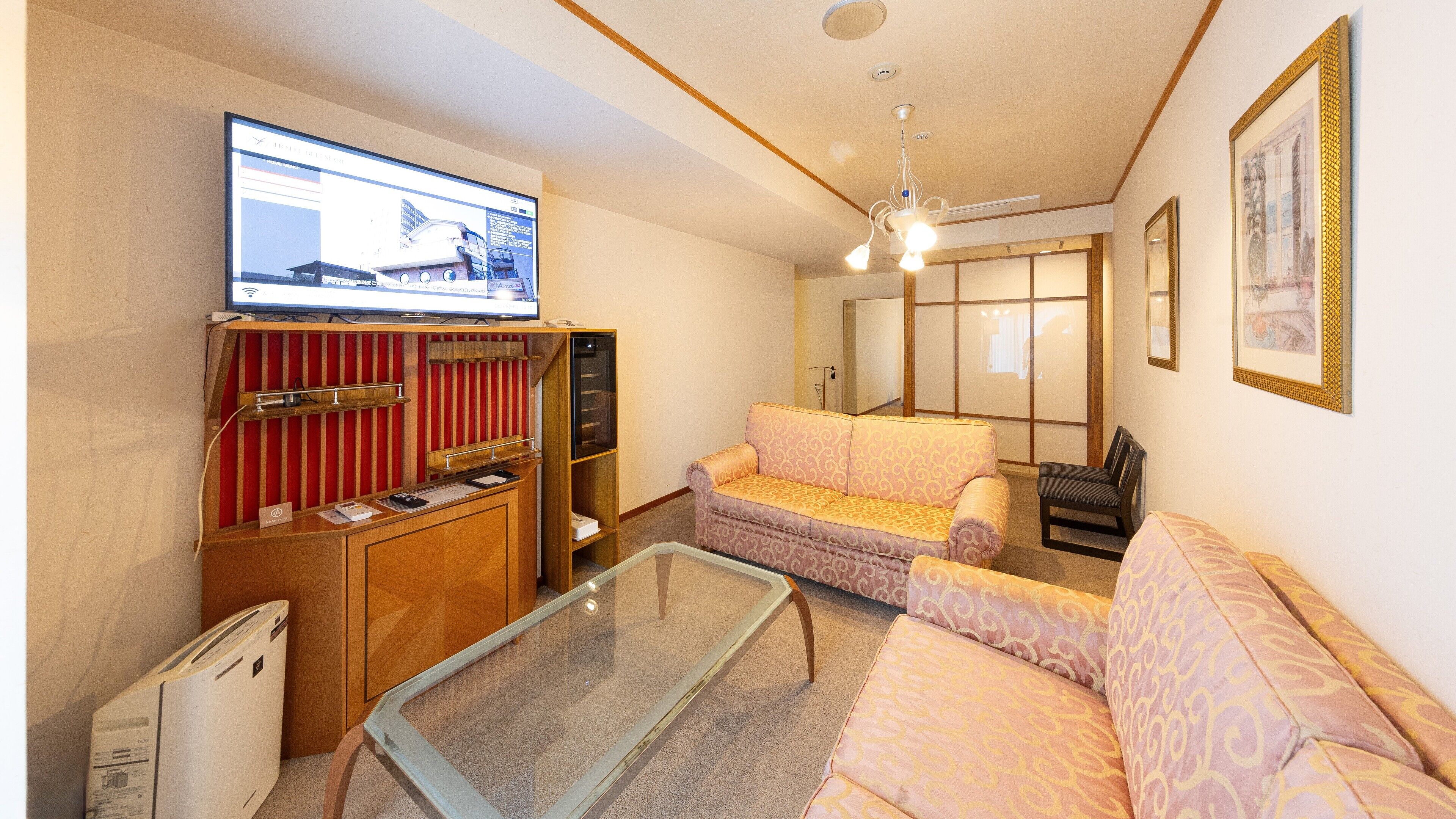 A living room with a sofa, a television, a small table, and a cabinet.