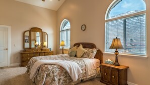 A bedroom with a large bed, a dresser, a nightstand, and a window with blinds. - Family Crash Pad near SLC (Farmington)