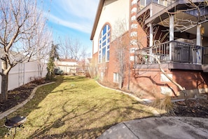 A residential building with a brick facade, a large arched window, and a balcony with railings. - Family Crash Pad near SLC (Farmington)