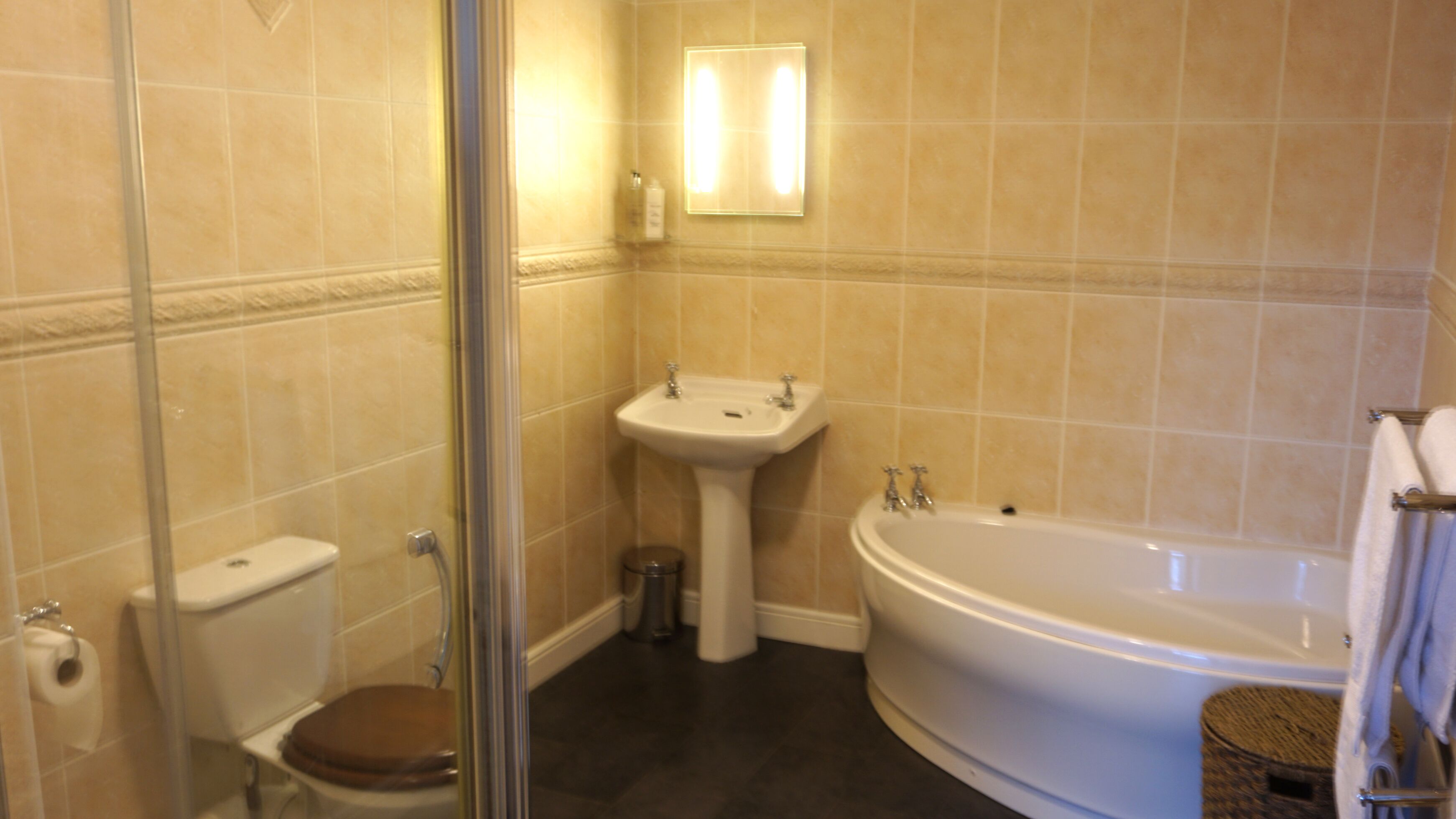 Een badkamer met toilet, wastafel en bad.