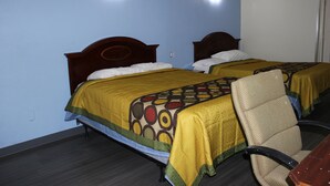 A hotel room with two beds, each with a wooden headboard, a yellow bedspread, and a chair with a woven seat. - Relax Inn (Canton)