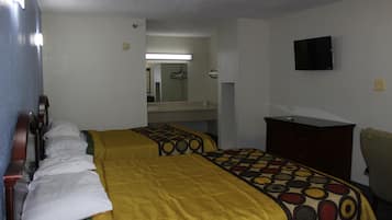 A hotel room with two beds, a television, a dresser, and a mirror.